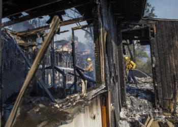 Los bomberos luchan contra el Getty Fire en casas en llamas en Brentwood, California, el 28 de octubre de 2019.