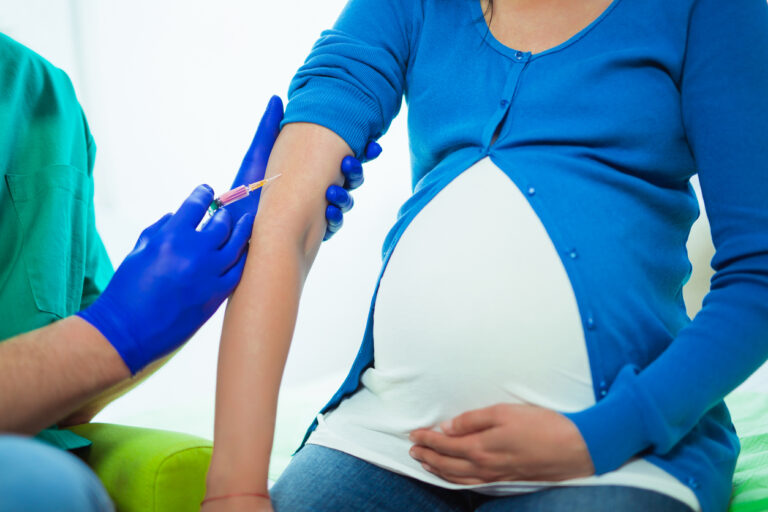 Doctor vaccinating young pregnant woman