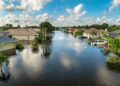 Calles y viviendas anegadas tras inundación, daños cubiertos por seguros contra fenómenos naturales
