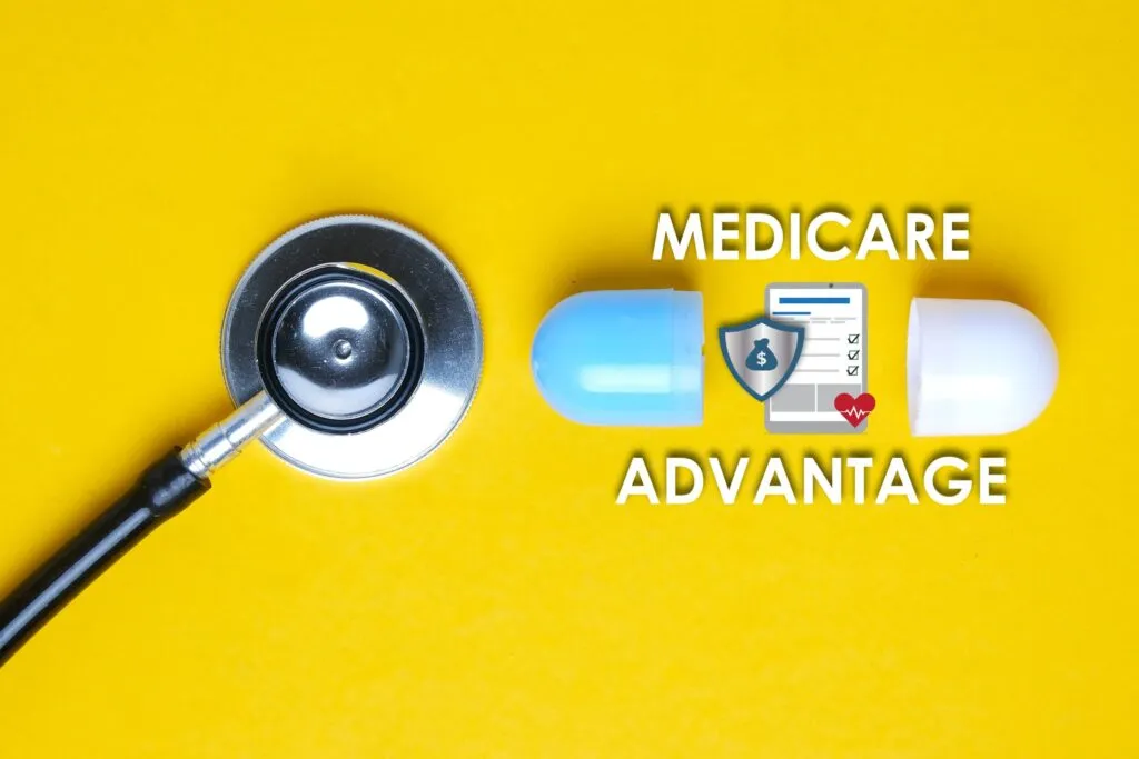 Estetoscopio y cápsula médica sobre fondo amarillo, con texto Medicare Advantage, ilustrando ajustes de aseguradoras en planes y beneficios para afiliados.