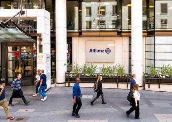 Fachada principal de Allianz House en Londres con transeúntes caminando frente al edificio de la aseguradora.