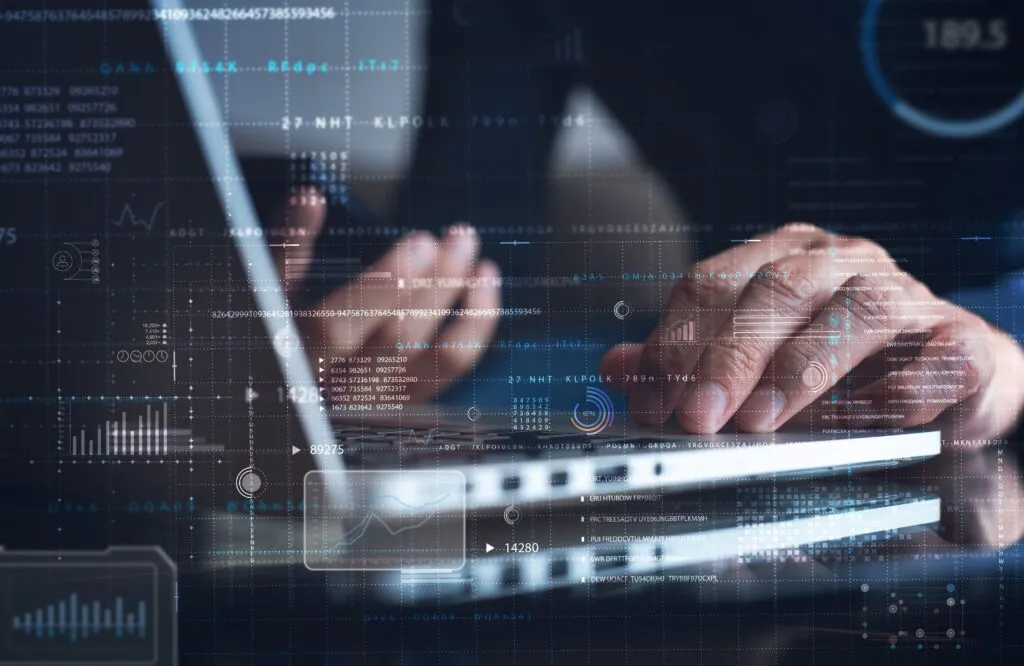 Manos trabajando en laptop con gráficos digitales que representan la digitalización con personalización en seguros en México, enfocada en innovación y análisis de datos.