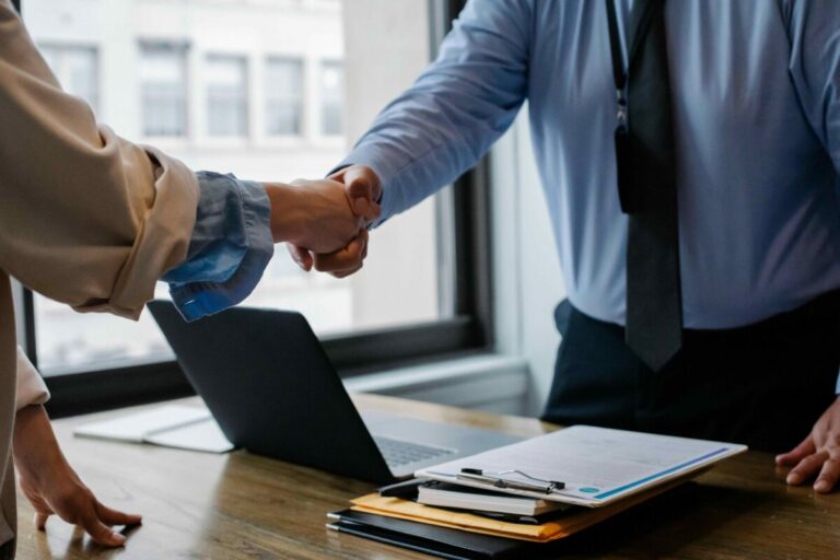 Agente de seguros mexicano ofreciendo asesoría personalizada a cliente en oficina moderna, destacando la importancia del servicio humano en el sector asegurador.