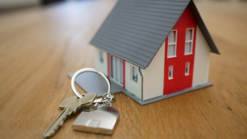 Propietario revisando vivienda con documentos de seguro de hogar en mano