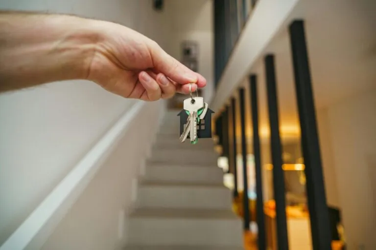 Agente inmobiliario mostrando casa durante el cierre federal en EE. UU., con documentos y señal de “en venta”