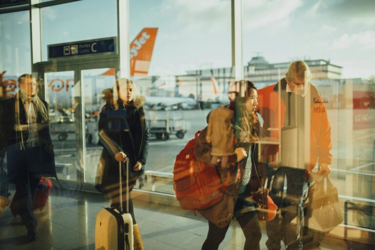 Personas en aeropuerto con maletas aseguradas, ilustrando la contratación de seguros de viaje vacacionales en España