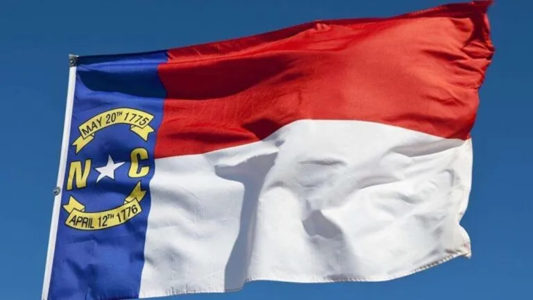 Documentos legales y símbolos regulatorios que ilustran las reformas de seguros en Carolina del Norte