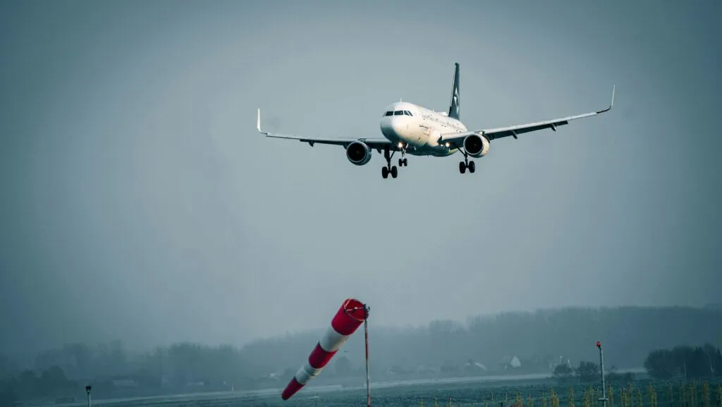 Ilustración editorial sobre seguros en aviación, mostrando aeronaves y elementos de carga y pista aérea