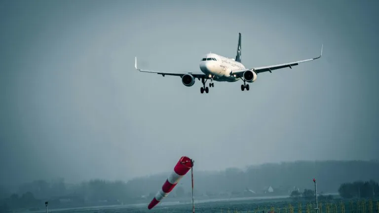 Ilustración editorial sobre seguros en aviación, mostrando aeronaves y elementos de carga y pista aérea