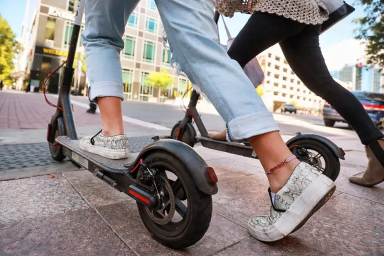 Personas circulando en patinetes eléctricos por una ciudad con nueva normativa de seguro obligatorio en vigor