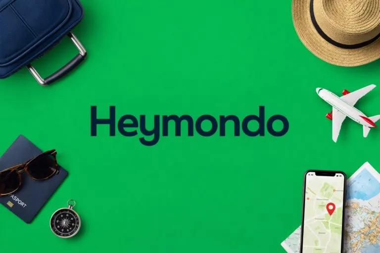 Personas sonrientes con maletas consultando seguros de viaje con descuentos de Heymondo