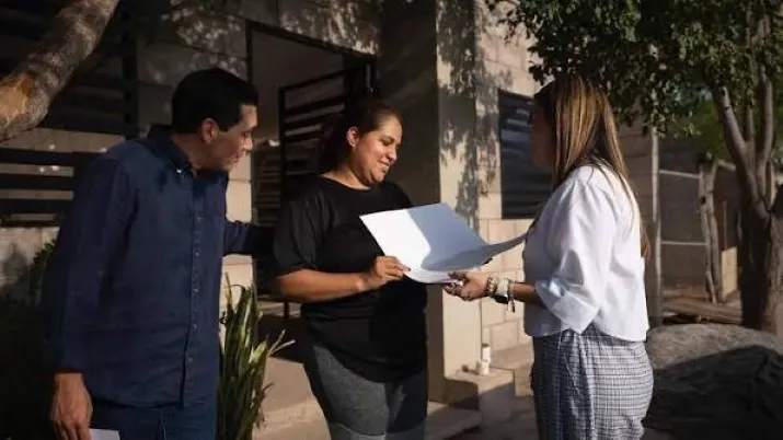 Familia mexicana revisa documentos de un seguro de vida para proteger su economía ante gastos inesperados.